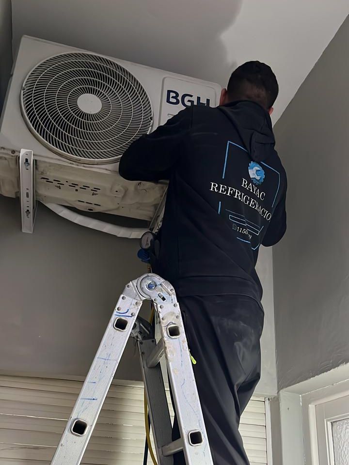 Técnico de BAYAC Refrigeración trabajando sobre una escalera en la unidad exterior de un aire BGH